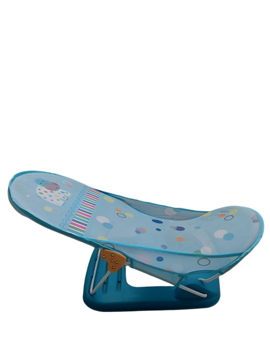 Blue baby bath seat with colorful patterns on a concrete floor.